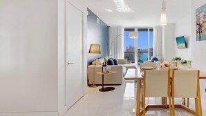 Een moderne woonkamer met een bank, eettafel en stoelen.