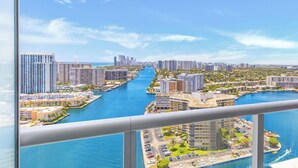 A high-rise building with a view of a marina and cityscape. - Infinite View Balcony|Studio Resort (Hallandale Beach)