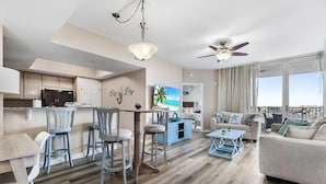 A modern living room with a sofa, coffee table, and dining area with chairs.
