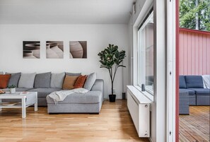 A modern living room with a grey sofa, a coffee table, and a potted plant.
