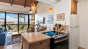 Una cocina moderna con horno empotrado, refrigerador y un comedor con mesa y sillas.