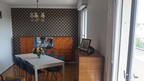 Un comedor con una mesa, sillas y un armario de madera.