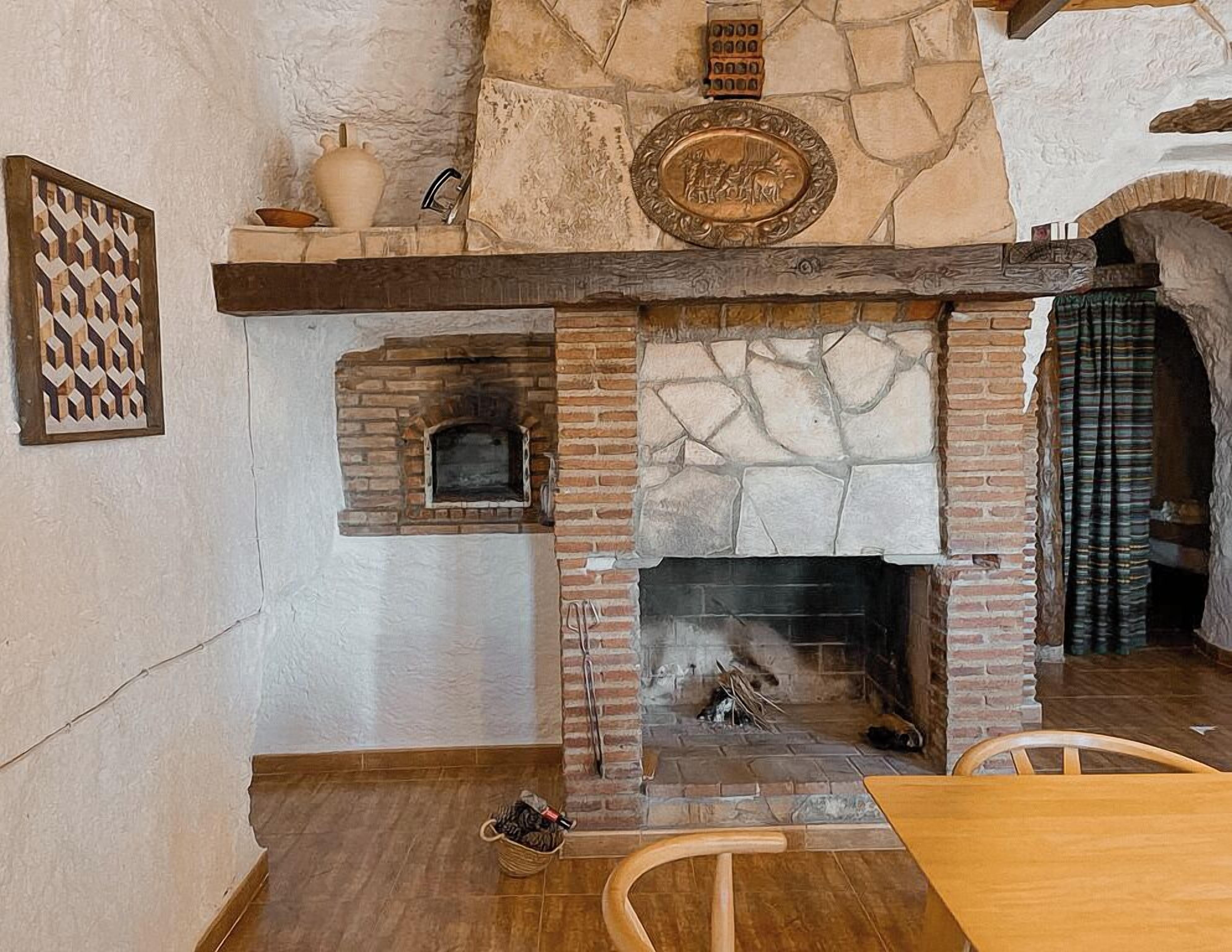 A stone fireplace with a brick surround, a decorative plate above it, and a woven basket on the floor.