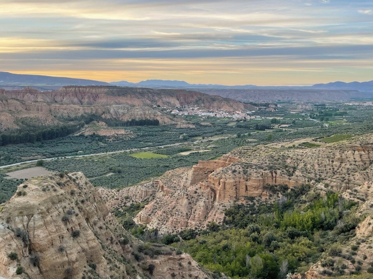 Vista panorámica de un paisaje escarpado con un pueblo enclavado en el valle.