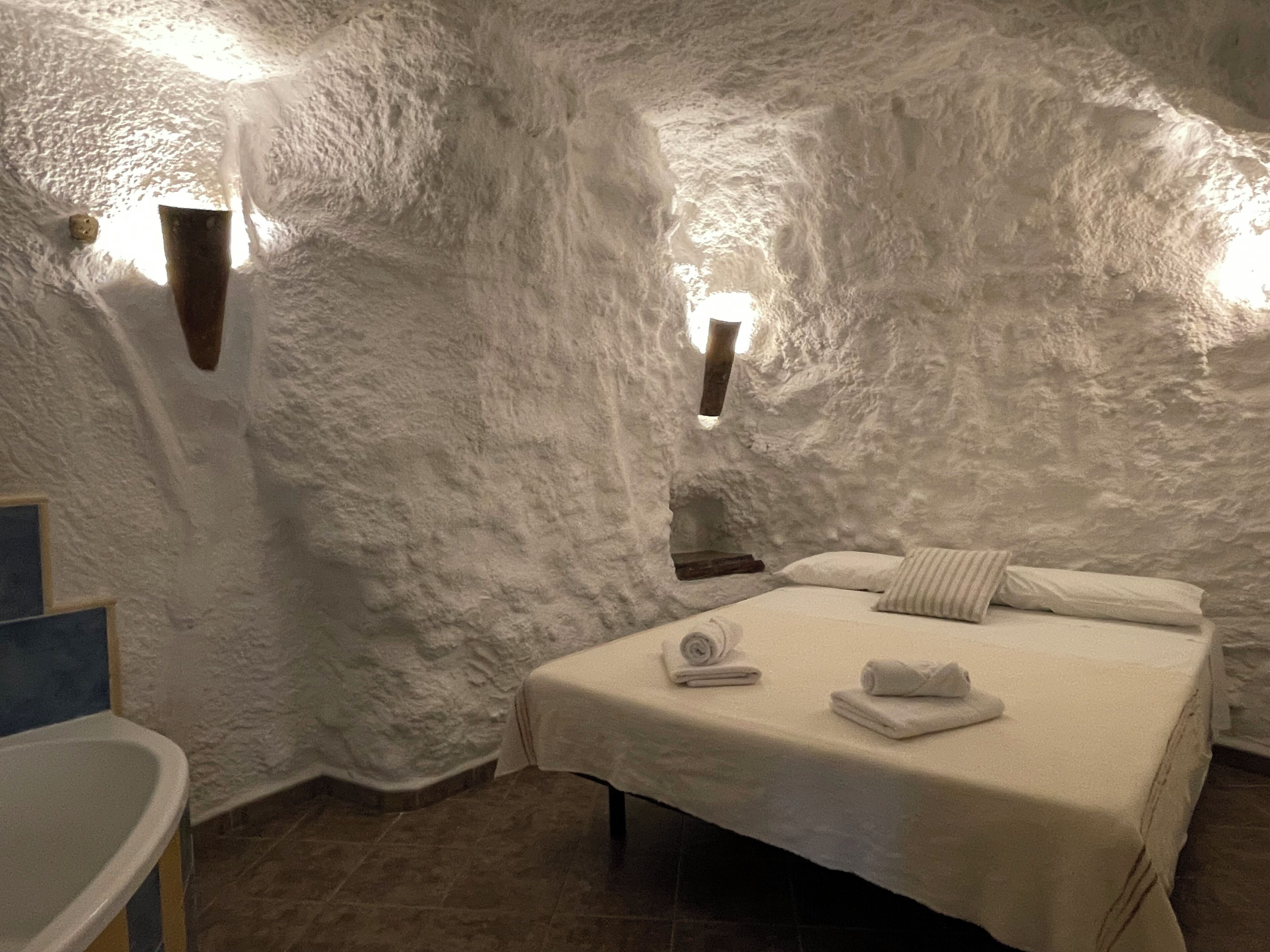 Un dormitorio rústico y acogedor con cama, almohadas y una colcha impecable.