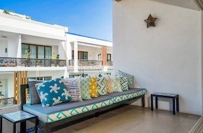 A balcony with a sofa, a small table, and a decorative star on the wall.