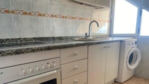 A kitchen with a built-in oven, a sink, and a washing machine. - PARQUEMAR I  6º ATICO SOLO FAMILIAS! (Xeraco Playa)