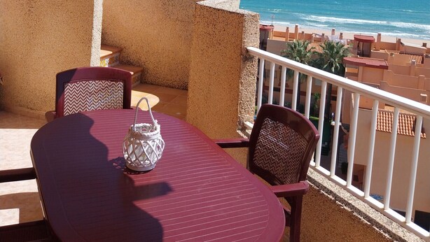 A balcony with a striped awning overlooking a beach. - PARQUEMAR I  6º ATICO SOLO FAMILIAS! (Xeraco Playa)
