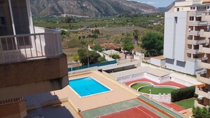 A residential area with a swimming pool, tennis courts, and a view of mountains. - PARQUEMAR I  6º ATICO SOLO FAMILIAS! (Xeraco Playa)