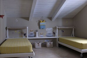 A children's room with bunk beds, a shelf with decorative items, and a white ceiling. - COCOSEA (Maratea)