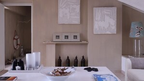 Ein modernes Wohnzimmer mit Kamin, abstrakten Wandbildern und einer gemütlichen Sitzecke.
