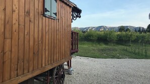 A wooden cabin with a window and a view of mountains. - Roulotte 2 Personnes (Saint-Rémy-de-Provence)