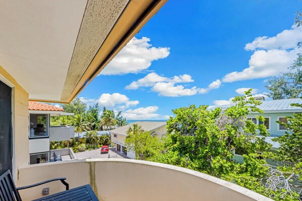 A balcony with a view of a residential area, including houses and greenery.