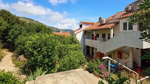 A residential building with a red-tiled roof, a visible staircase, and a garden area with various plants. - Hedera Estate, Hedera A16 (Dubrovnik)