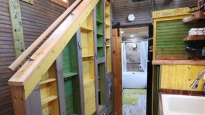 Un couloir étroit aux murs en bois et un escalier.