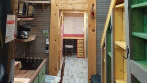Une cuisine compacte dotée de meubles en bois, d’une cuisinière intégrée et d’un coin repas avec une chaise.