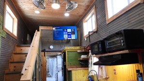 Une cuisine compacte équipée d’un four à micro-ondes, d’un évier et d’un escalier en bois.