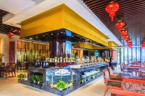 A modern restaurant with a central bar area, seating arrangements, and decorative elements.