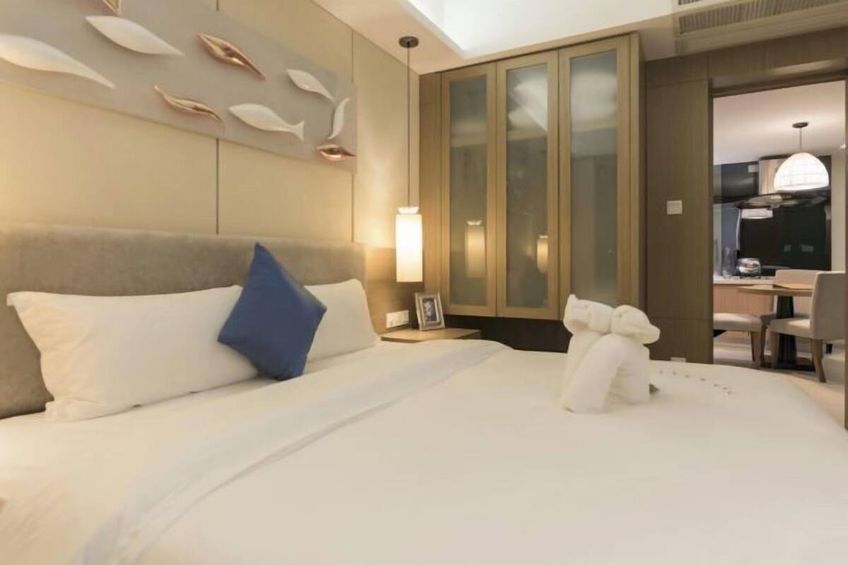 Hotelkamer met een bed, nachtkastje, een wandlamp en een kledingkast met ruitenverdeling.