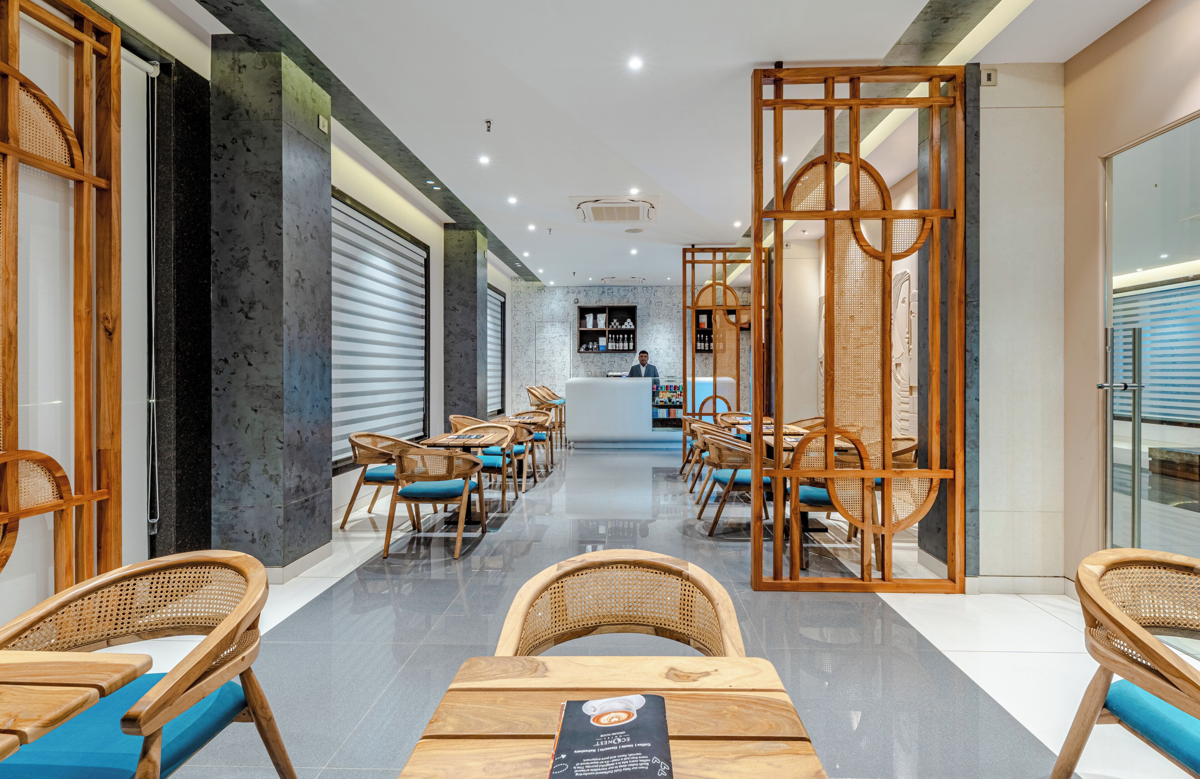 Een hotel lobby met een receptiebalie, rieten meubels en een modern interieur.