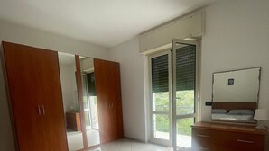 Ein Schlafzimmer mit Bett, Kleiderschrank und Fernseher.