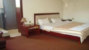 Un dormitorio con una cama grande, una mesita de noche y un escritorio.