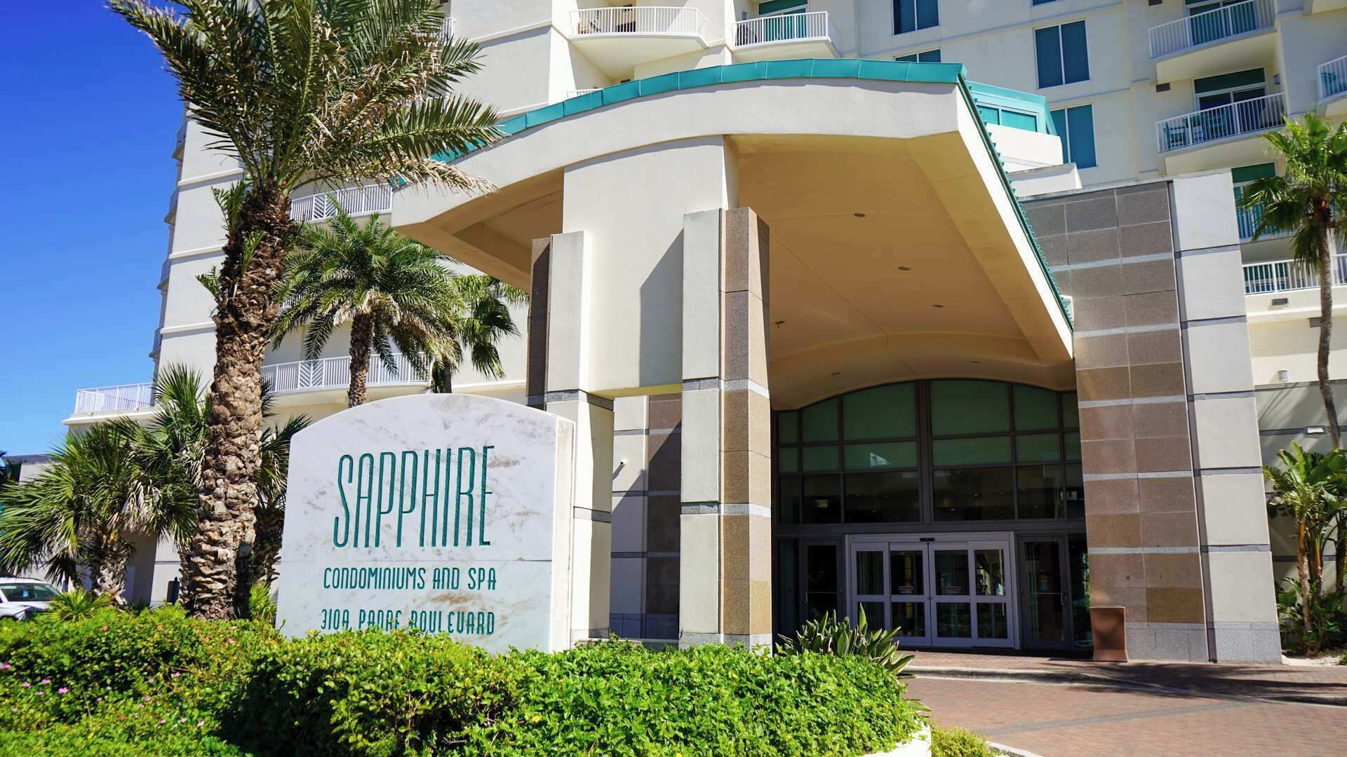A hotel entrance with a sign reading "Sapphire Condominiums and Spa" at 3109 Padre Boulevard.