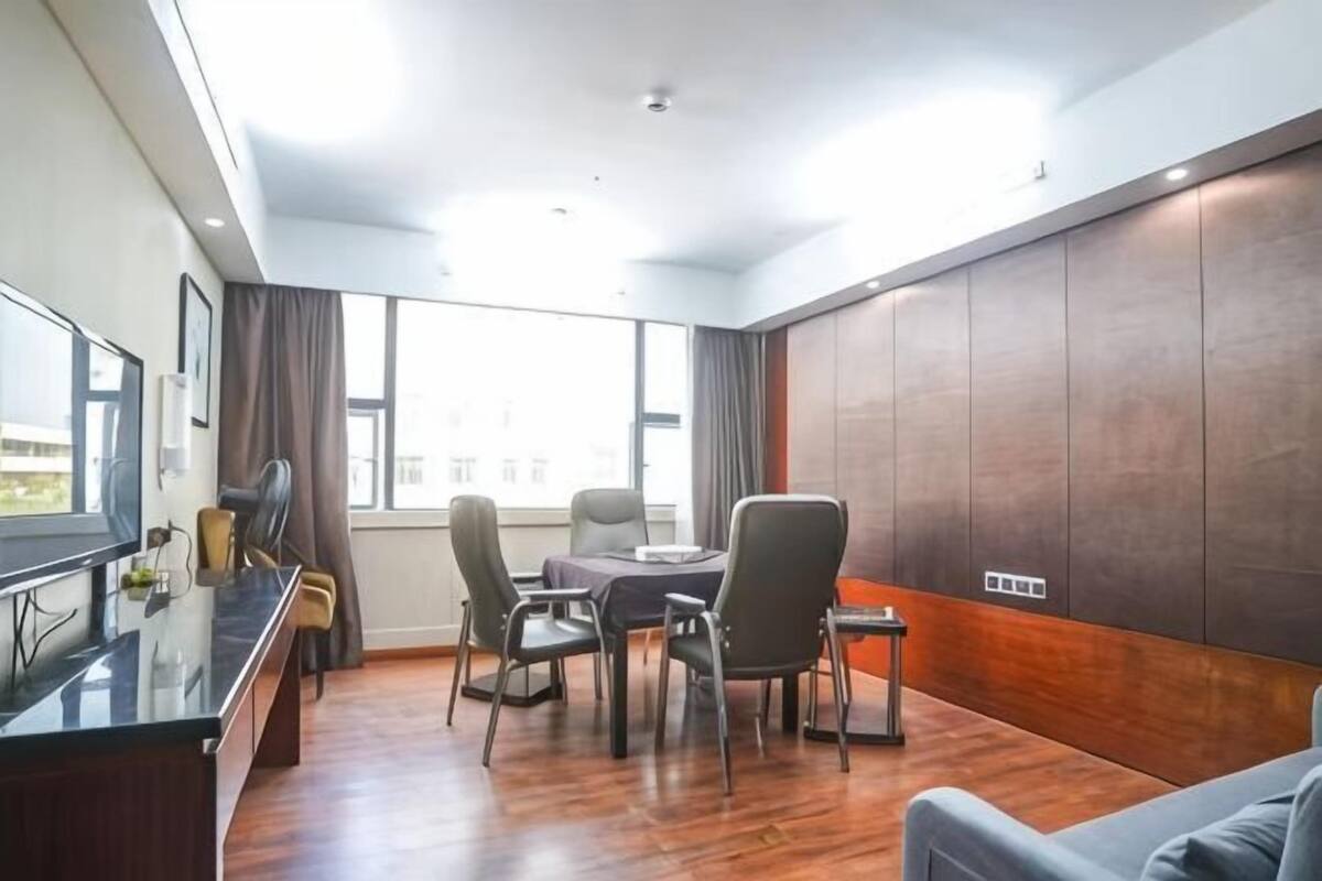 Une salle de conférence moderne, dotée d’une grande table, de nombreuses chaises, d’un téléviseur et offrant une vue dégagée grâce à de grandes fenêtres.