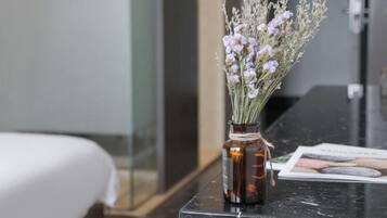 A marble countertop with a small vase containing lavender flowers.