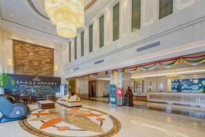 A spacious lobby with a central seating area, a reception desk, and a large mural on the wall. - Zhongjiang Hotel (Tongling)