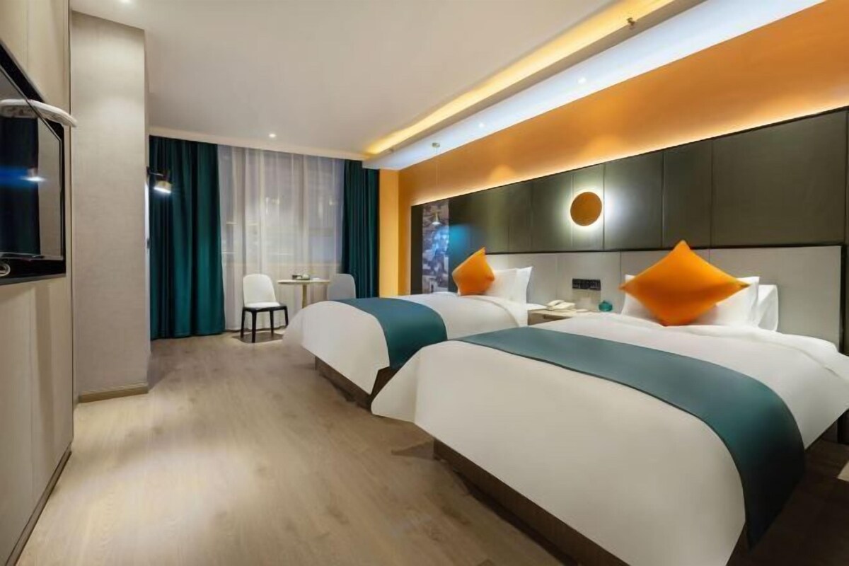 Una habitación de hotel moderna con dos camas, un escritorio y una silla.