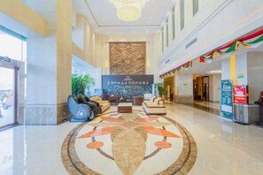 A spacious lobby with a central seating area, a reception desk, and a large wall mural. - Zhongjiang Hotel (Tongling)