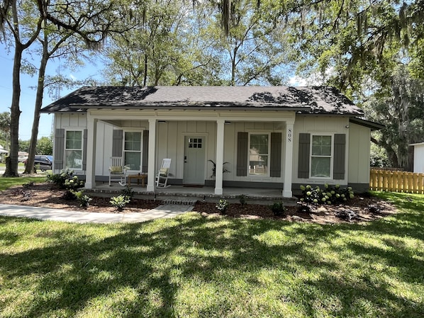 A single-story house with a porch, a front door, and a mailbox.