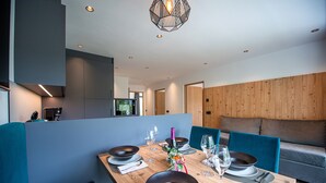Un comedor moderno con una mesa de madera dispuesta para cuatro personas, rodeada de sillas azules.