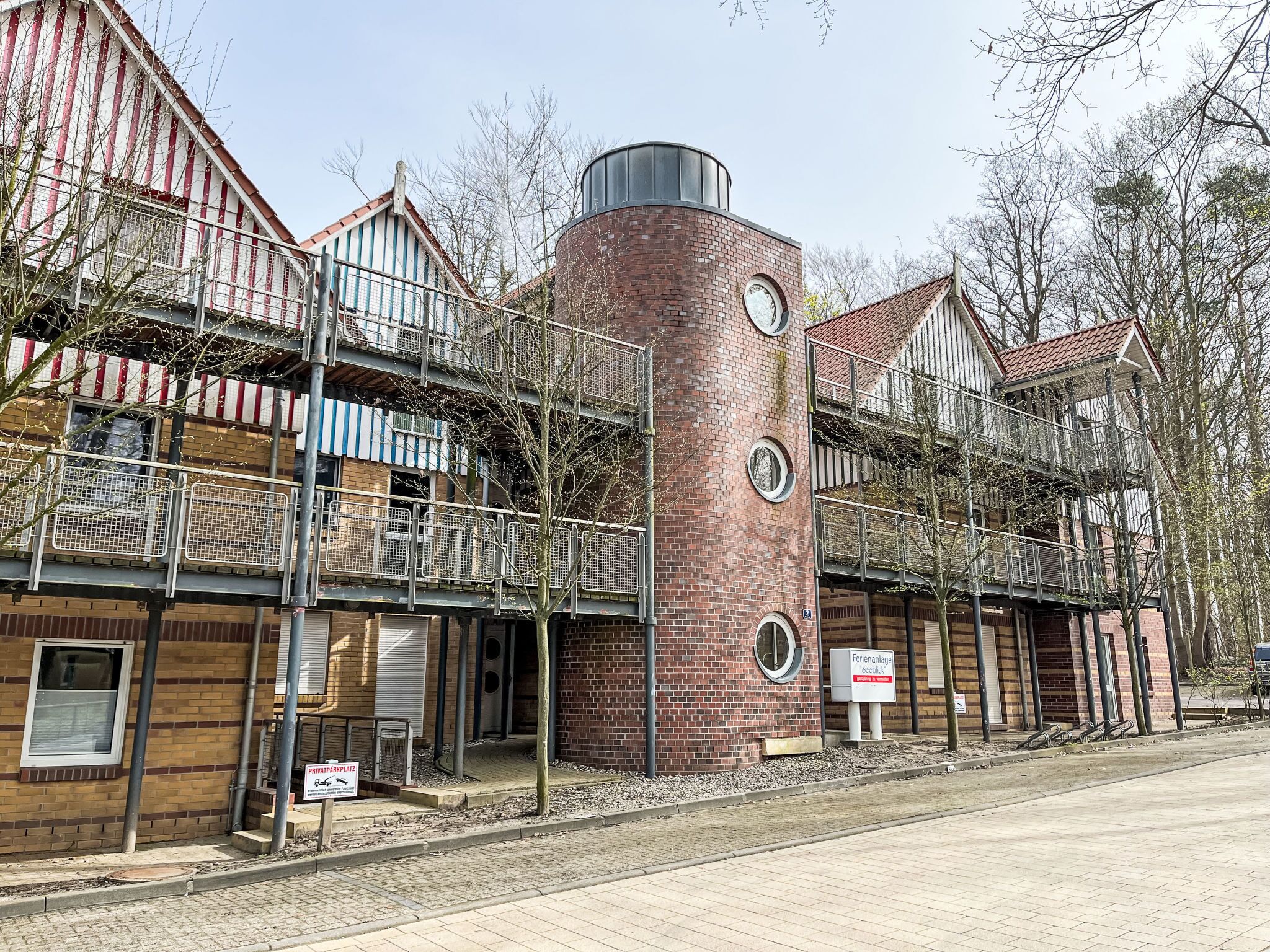 Ein Gebäude mit Backsteinfassade, mehreren Balkonen und einer zylindrischen Struktur.
