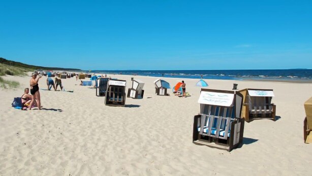 A beach with several wooden beach chairs and umbrellas. - Vacation home Ehmke by Interhome (Karlshagen)