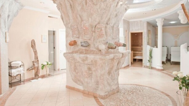 A lobby with a large tree sculpture, a reception desk, and a circular mosaic floor. - Apartment Top 4 by Interhome (Ischgl)