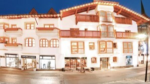 Un bâtiment européen traditionnel, à étages multiples, doté de balcons et surmonté d’une flèche imposante.
