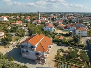 Vista aérea de una zona residencial con casas, una iglesia con una torre destacada y una calle pavimentada.