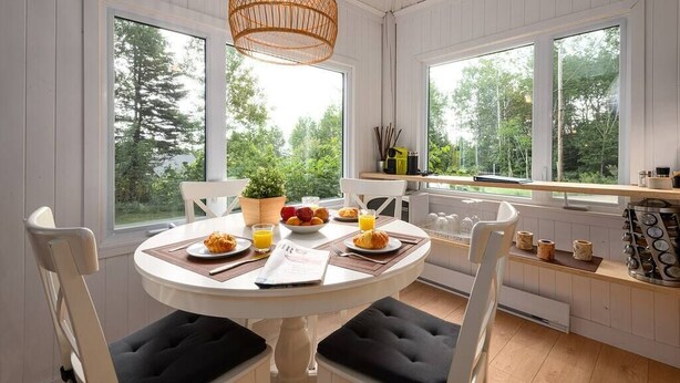 Un'area pranzo con un tavolo rotondo, sedie e un lampadario.