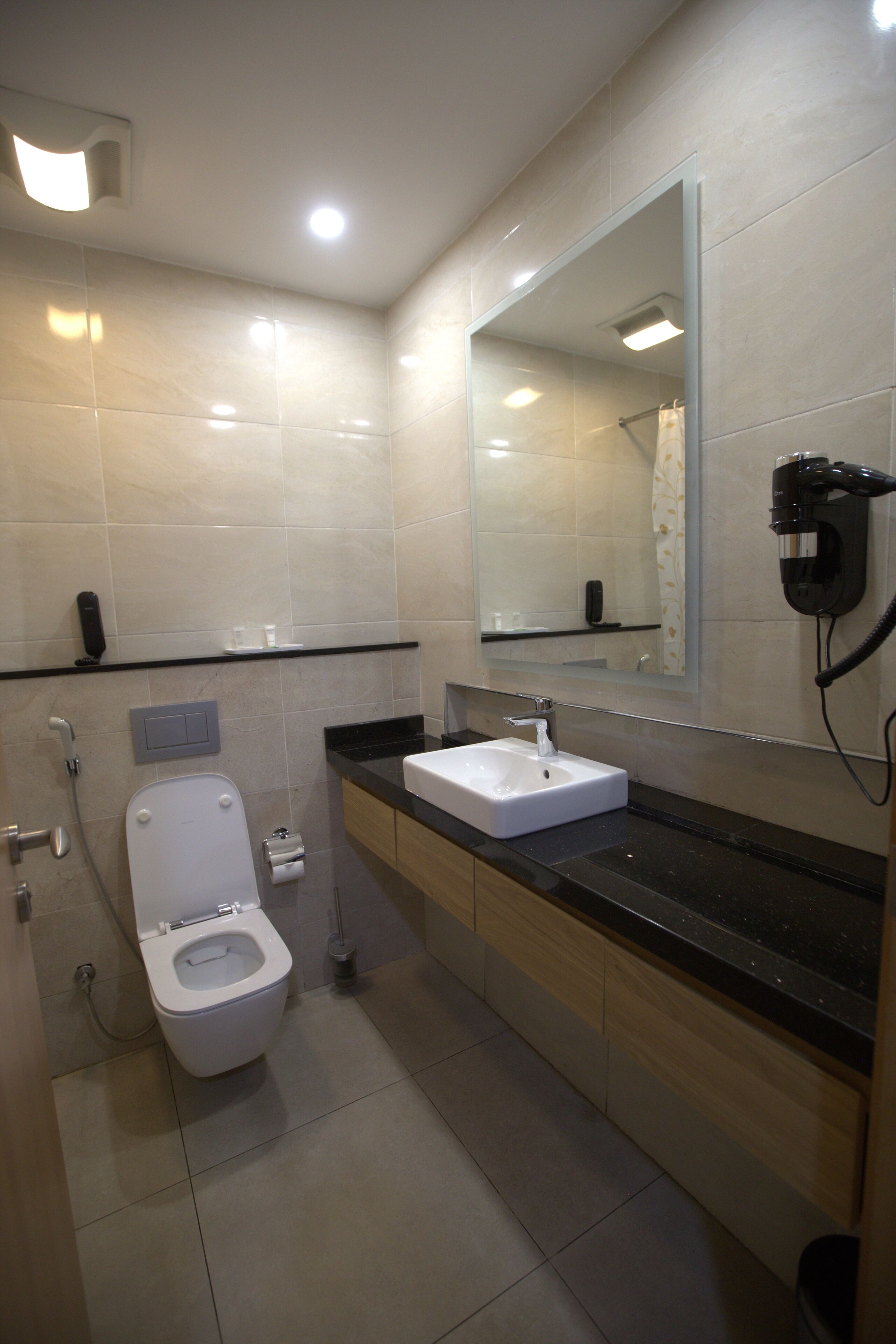 Une salle de bain moderne avec des toilettes, un lavabo et un miroir.