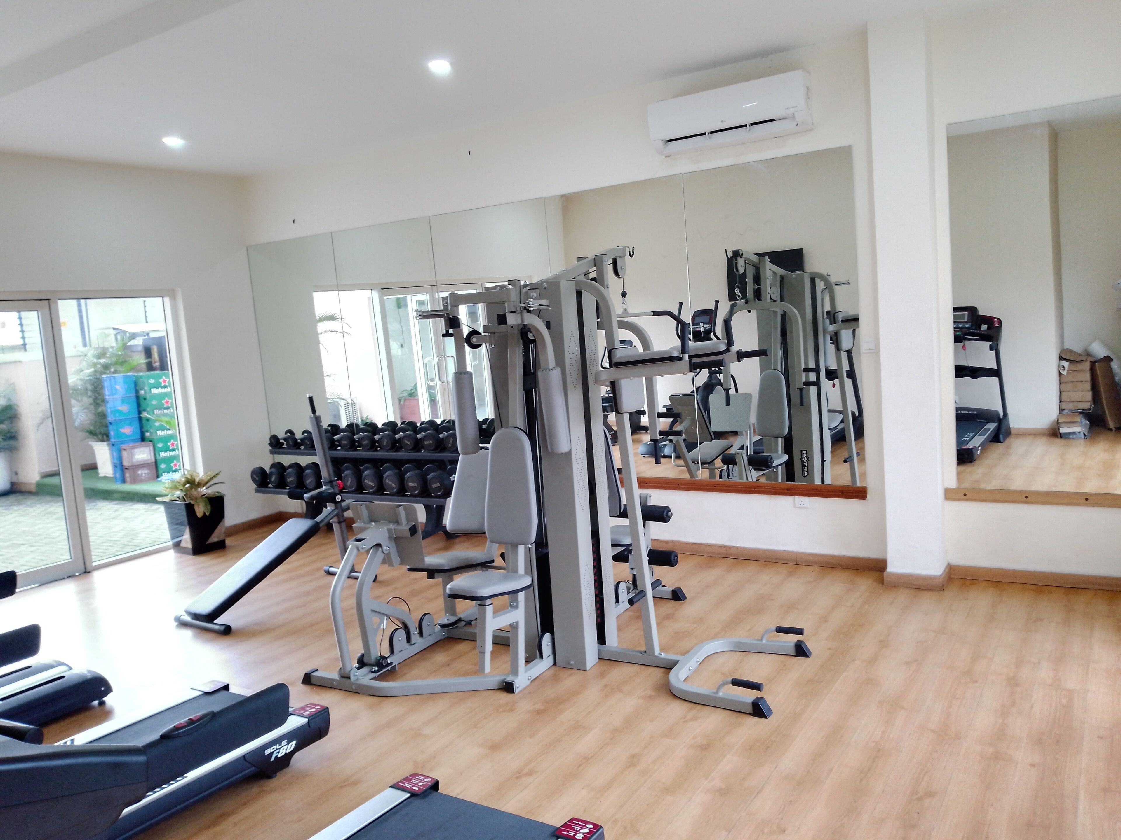 A gym with cardio equipment, weight machines, and dumbbells.