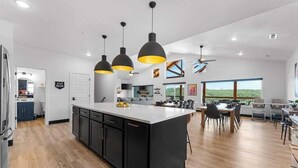 A modern kitchen with a central island, pendant lighting, and a view to the outdoors. - Lake View|Pools·Sauna·Hot Tub|Game&Theater Room·24 (Branson)
