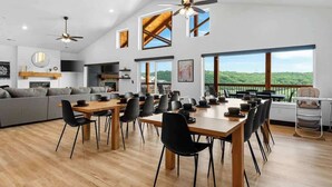 A spacious dining area with a high ceiling, large windows, and a view of the outdoors. - Lake View|Pools·Sauna·Hot Tub|Game&Theater Room·24 (Branson)