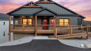 A two-story building with a wooden deck, a red door, and a sign indicating it is a restaurant. - Lake View|Pools·Sauna·Hot Tub|Game&Theater Room·24 (Branson)