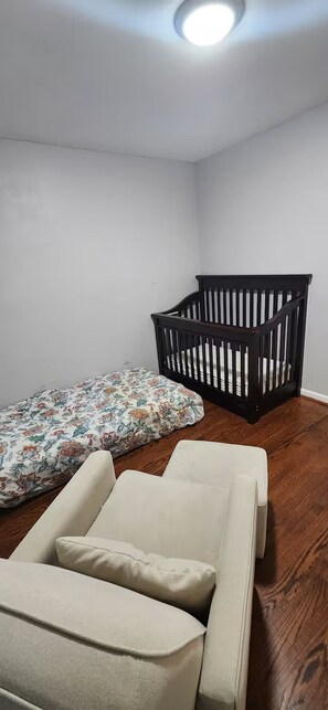 Une pièce avec un berceau, un banc rembourré et un coussin à motifs.