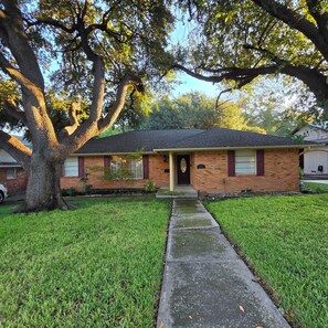 A single-story brick house with a front porch, a lawn, and a large tree. - Cozy 3bdrm 2bath house for families w/ small kids & infants near White Rock Lake (Dallas)