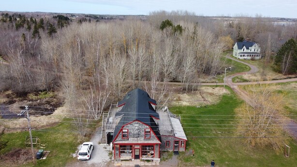 A large, two-story building with a steep roof, a red and white facade, and a small porch area. - Trailside Inn (Mount Stewart)