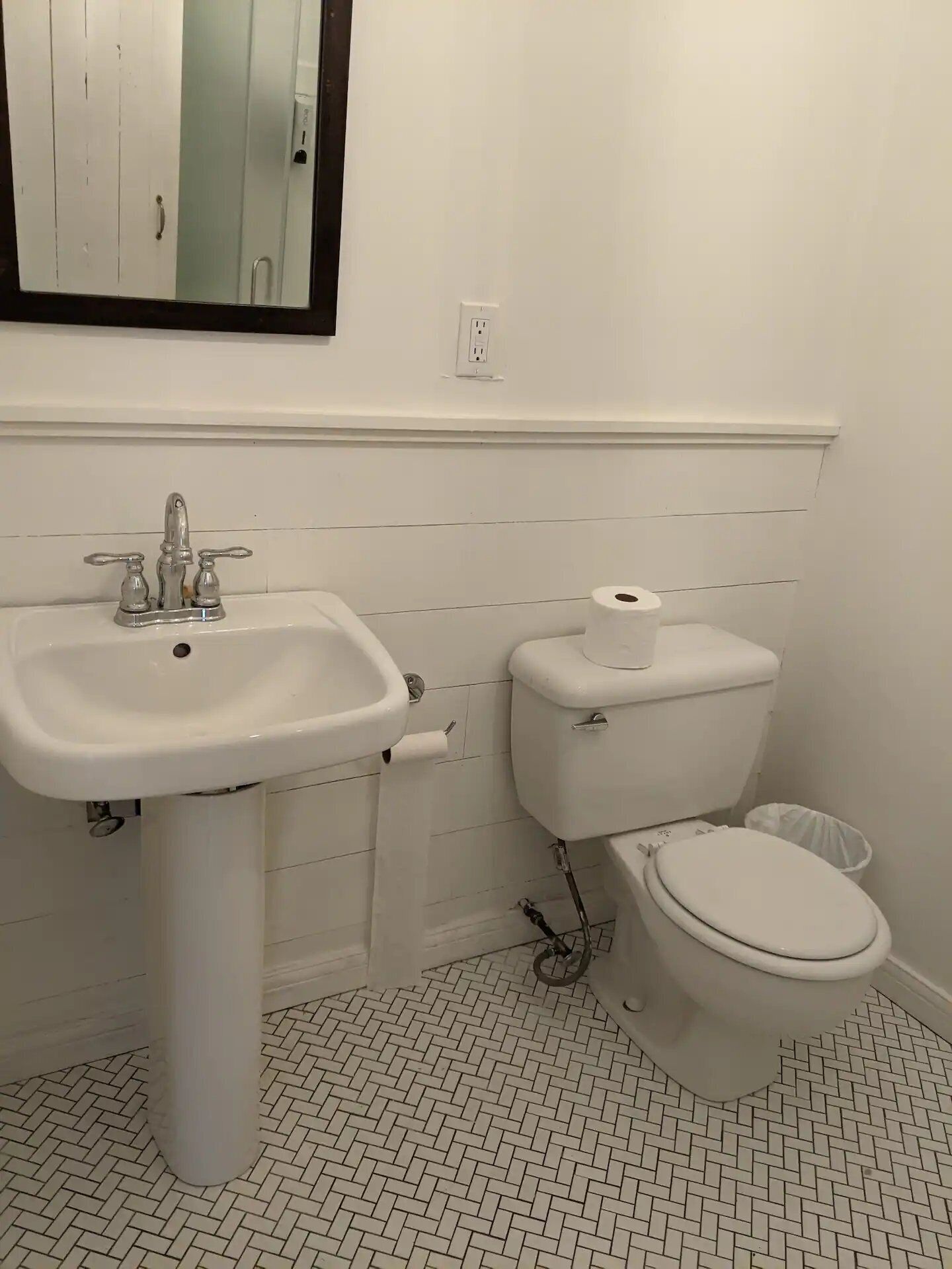 Un bagno con lavandino, water e bidet bianchi.