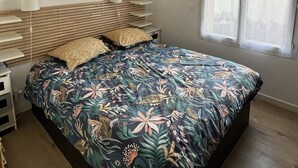 A bedroom with a bed, bedside tables, a hanging light fixture, and a window. - A 5 du Centre et des Plages, Maison Avec Jacuzzi (Sanary-sur-Mer)